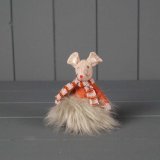 A mouse decoration in a rusty orange colour wearing a faux fur skirt and striped scarf.