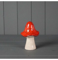 A charming decoration featuring a woodland mushroom in dark red tones.
