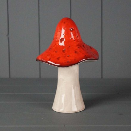 A ceramic mushroom, topped with dark red tones and finished with a simple glaze.