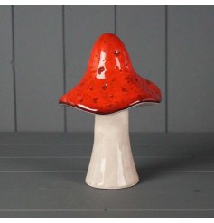 A ceramic mushroom, topped with dark red tones and finished with a simple glaze.