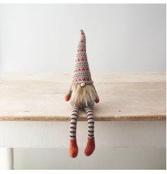 A cute shelf sitting gonk decoration with long striped dangly legs, fluffy beard and patterned hat. 