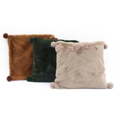 An assortment of beautifully textured faux fur cushions in earthy green, gold and cream colours. Complete with pom poms