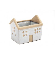 A stoneware planter with a house shaped design featuring contrasting window and door detailing. 