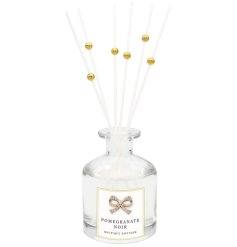 A beautifully scented Pomegranate Noir reed diffuser in boutique packaging with a diamond bow. 