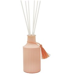 A pretty in peach ribbed diffuser bottle with a fresh and floral peony and blush fragrance.