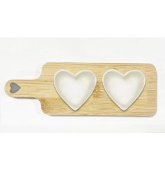 A wooden tray with 2 ceramic heart dishes