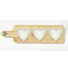 A wooden tray with 3 ceramic heart dishes
