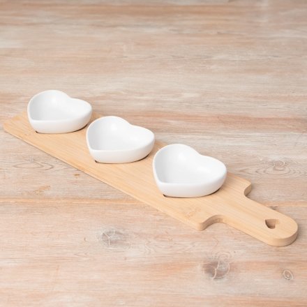 A wooden tray with 3 ceramic heart dishes