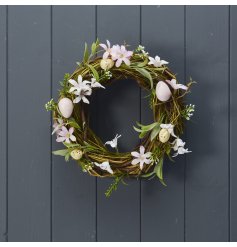 A stylish artificial floral wreath with speckled egg details and colourful spring flower adornments. 