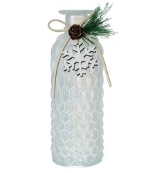 A honeycomb style glass jar with a frosted finish, wooden snowflake and seasonal foliage. 