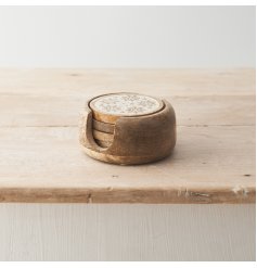 A set of 4 mango wood coasters featuring delicate snowflake and star patterns. 