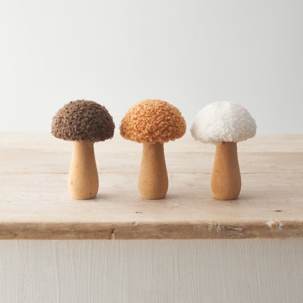 An assortment of 3 wooden mushrooms each with sherpa caps in cream, honey and brown colours. 