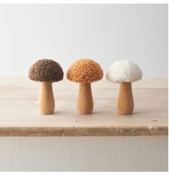An assortment of 3 wooden mushrooms each with sherpa caps in cream, honey and brown colours. 