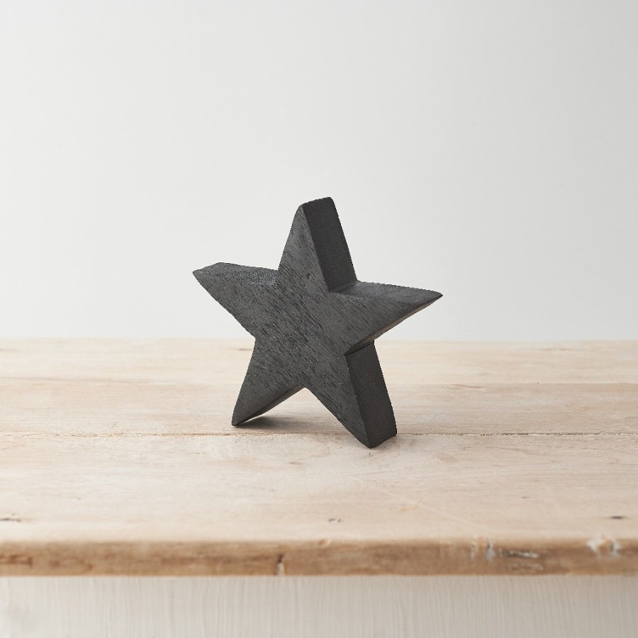 A chunky wooden star made from mango wood. Complete with a black painted finish with visible wood grain. 