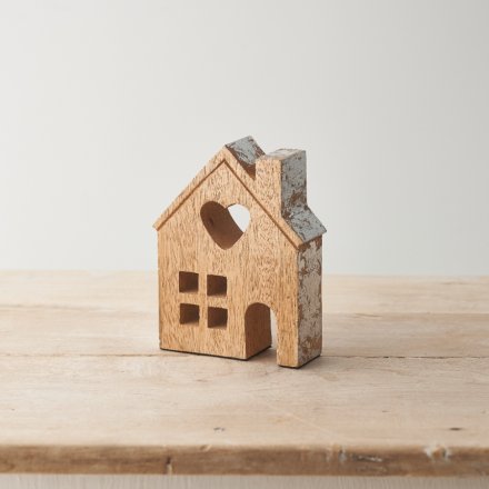 A contemporary wooden house ornament with a heart shaped cut out feature. 