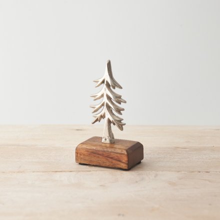 A stylish and unique metal Christmas tree ornament set upon a chunky wooden base. 