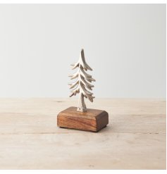 A stylish and unique metal Christmas tree ornament set upon a chunky wooden base. 