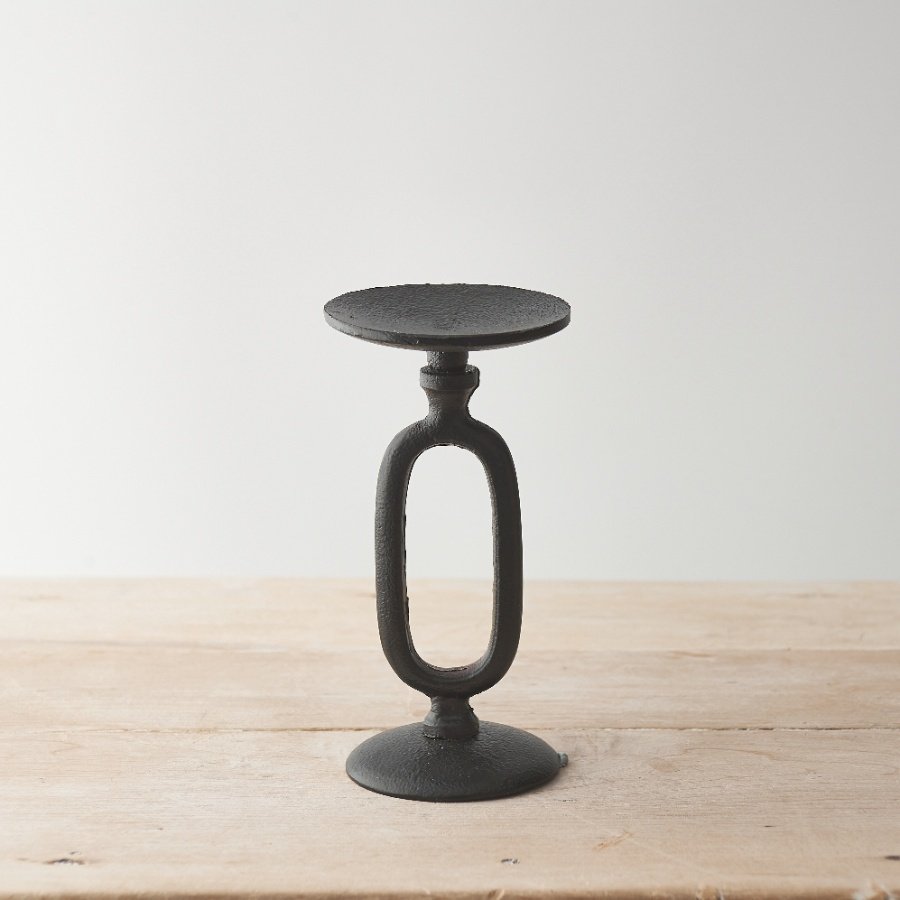 A chic and minimalist metal candle stand with a sculptural loop design. Complete with a black, hammered finish. 