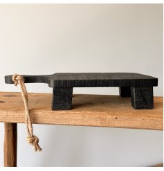Display candles, plants, decorative objects and more with this chunky wooden stand with feet and rope handle. 