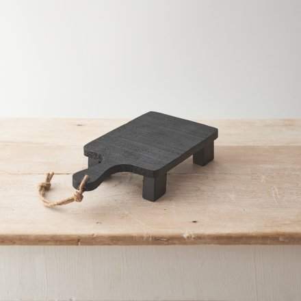 A chunky board with feet and handle, which has been crafted from natural mango wood and finished in black.