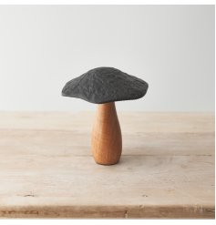 A rustic mushroom ornament made from natural mango wood. Complete with a hammered black metal cap.