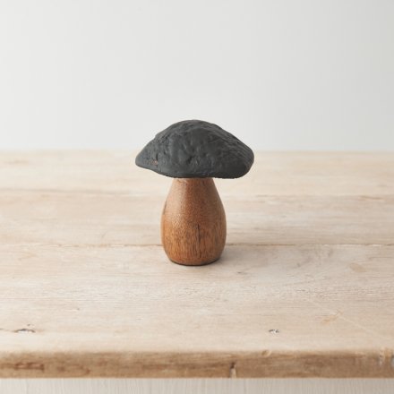 A rustic mushroom ornament crafted from mango wood and hammered metal. 