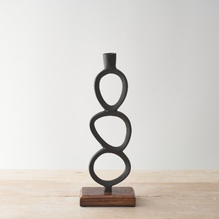 A contemporary candlestick holder with a black loop sculptural design. Set upon a chunky mango wood base. 