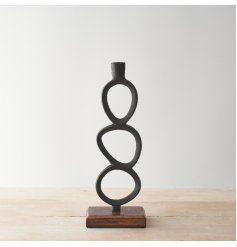 A contemporary candlestick holder with a black loop sculptural design. Set upon a chunky mango wood base. 