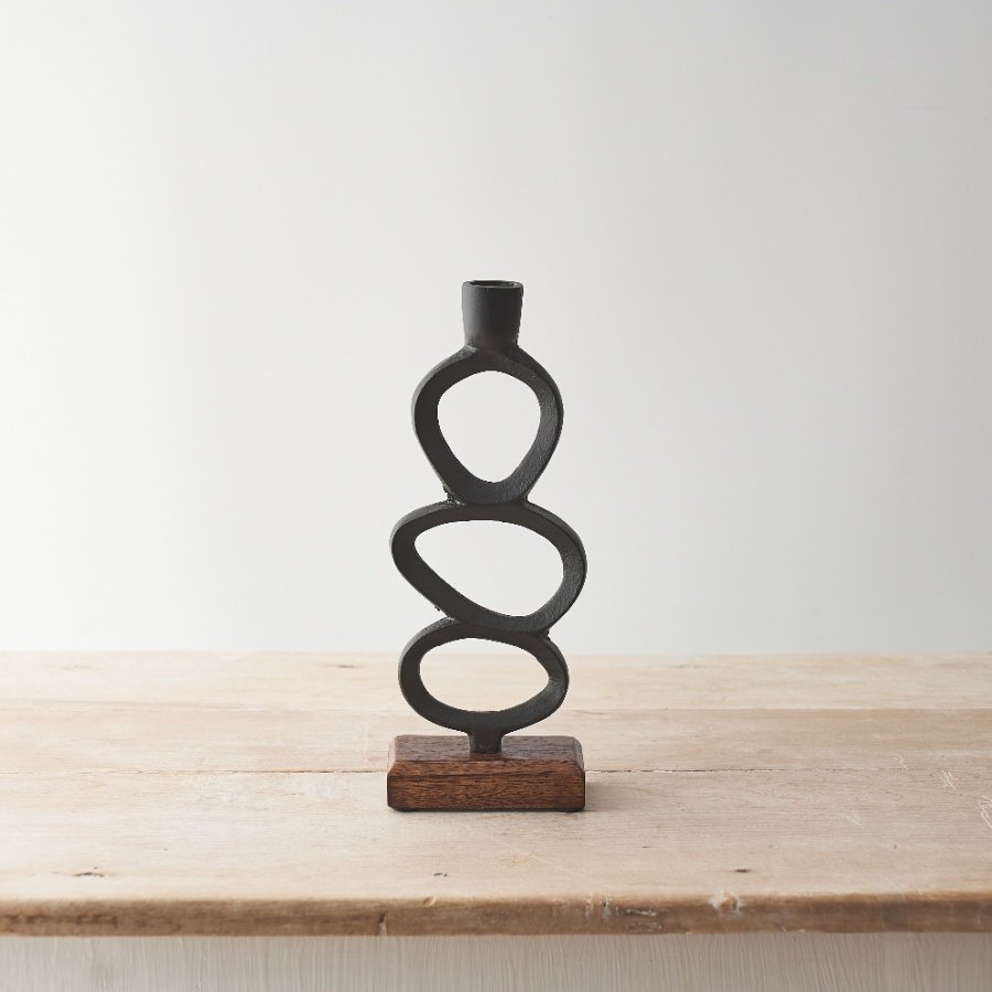 A stylish candle stick holder crafted from hammered metal and set upon a chunky mango wood base. 