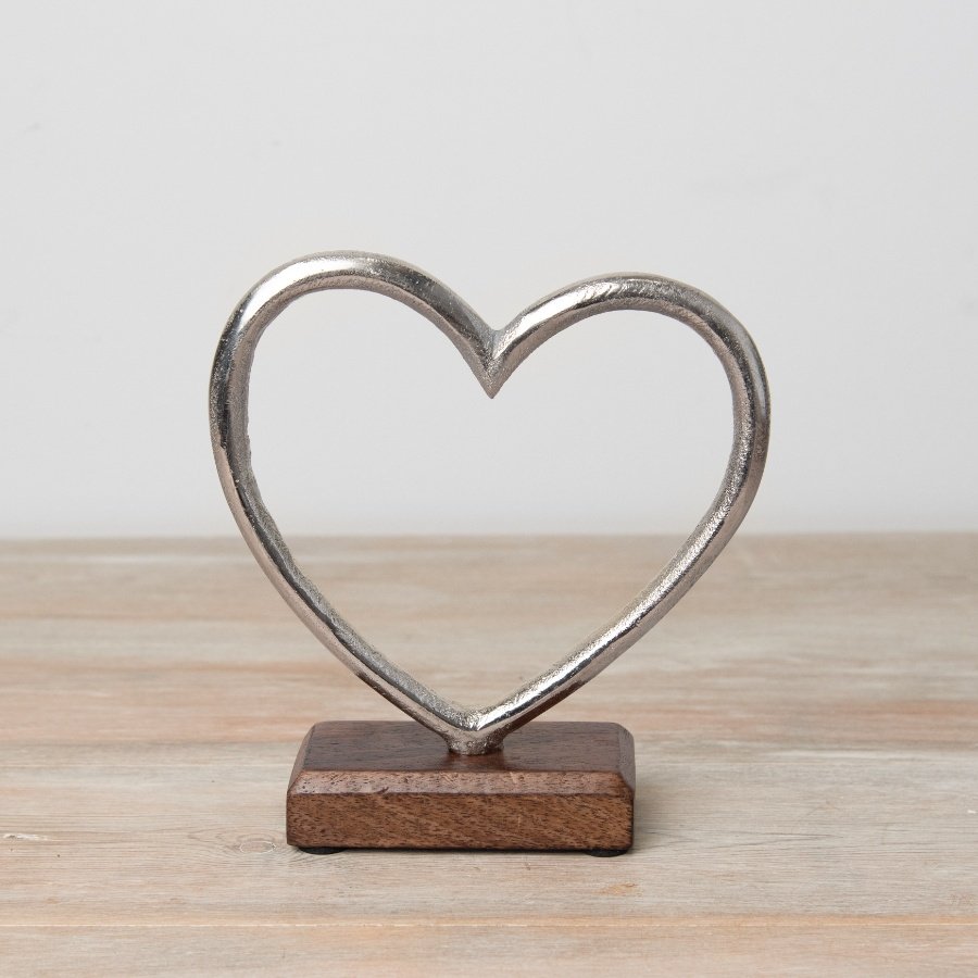 A silver metallic heart set onto a wooden base