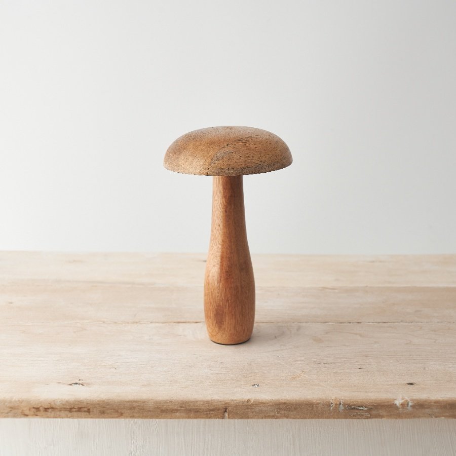 A contemporary mushroom ornament crafted from natural mango wood. With visible wood grain and a smooth finish