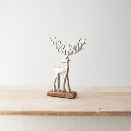 Stood on a chunky base made from wood, a silver standing reindeer.