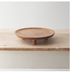 A stylish round tray with feet. Crafted from natural mango wood with a smooth finish and visible wood grain. 