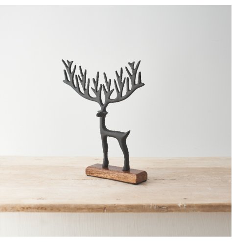 A decorative reindeer on a contrasting wooden base featuring a stylish black finish and sculptural antlers.