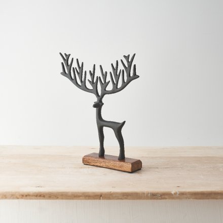 A stylish reindeer decoration featuring a sculptural black finish reindeer on a contrasting wooden base. 
