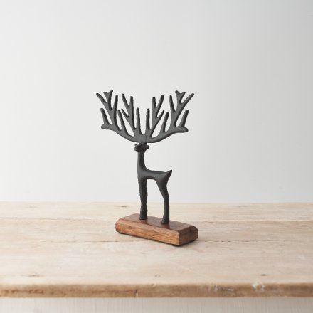 A striking decorative item featuring a black painted reindeer design with exaggerated antlers on a wooden base. 