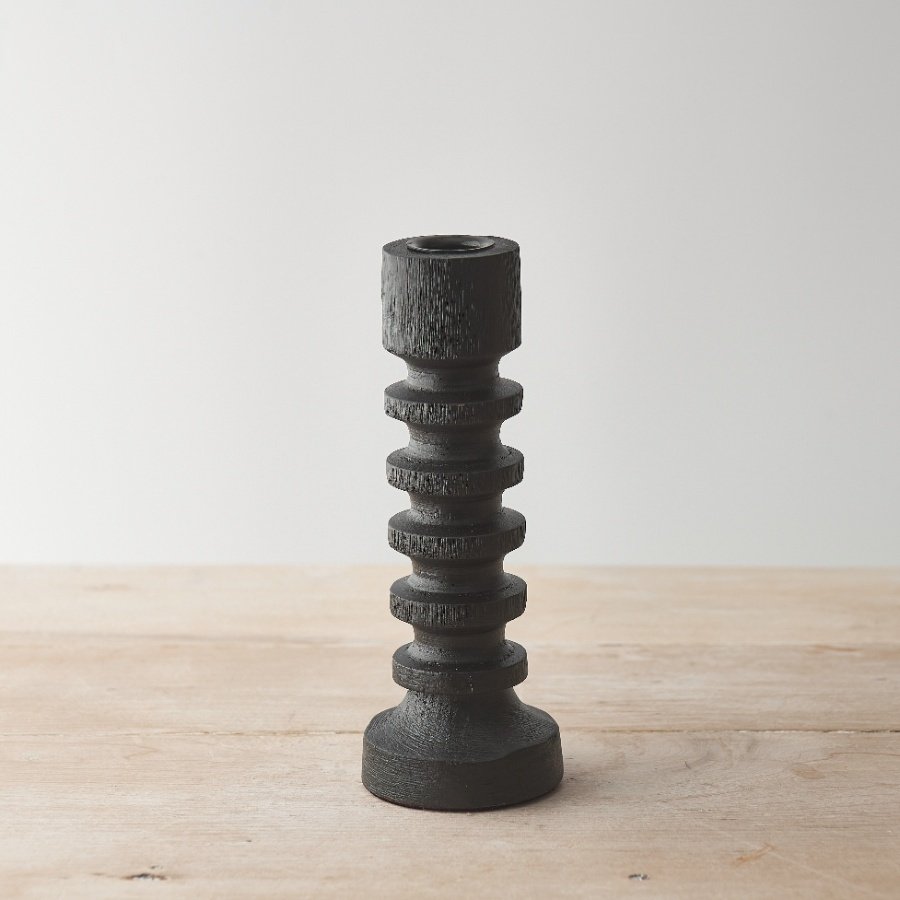 A chic candle pillar with black painted finish and a stylish sculptural design. 