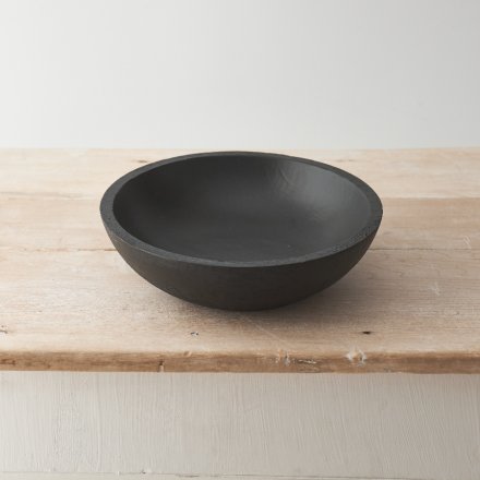 A sculptural dish crafted from natural mango wood with a black finish. 
