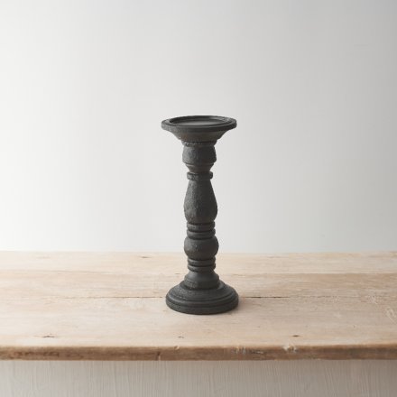 A chic and minimalist candle stand with a sculptural design and painted black finish. 