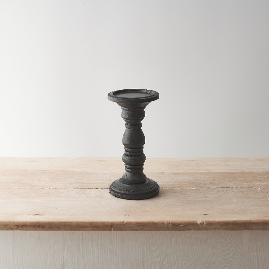 A stylish wooden candle stand with a contemporary sculptural design and chic black painted finish. 