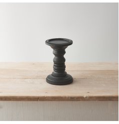 This wooden candle stand has a simple yet sculptural design, with a black painted finish