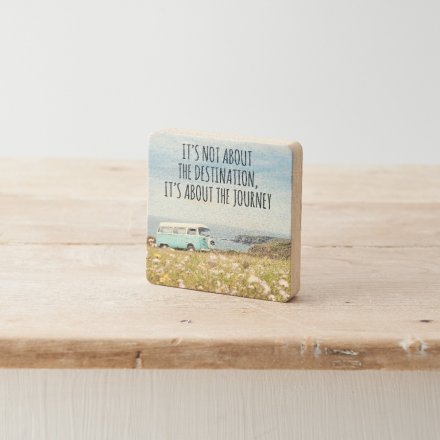 A decorative wooden block with motivational quote and beautiful ocean scenery print. 