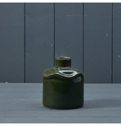 A beautifully crafted ceramic vase with an irregular shape and a glossy green glaze. 