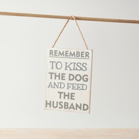 A humorous sign with distressed background and "remember to kiss the dog and feed the husband" text.