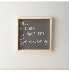 A stylish framed wooden sign with "this kitchen is made for dancing" text on a dark background. 