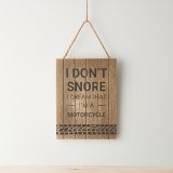 A panelled wood hanging sign with funny "I don't snore, I dream that I'm a motorcycle" text with tyre print design. 