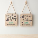 A reversible wooden hanging sign with "the cat/dog has/ has not been fed" wording and paw print details. 