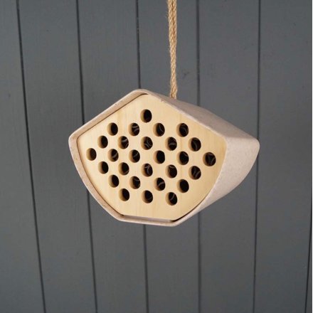 A yellow and natural bee house hung from jute twine