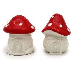 A whimsical and unique salt and pepper set in the shape of fairy toadstool houses, each with a polkadot roof.