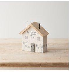 A unique crafted wooden house with intricate details and a charming slogan sign. 